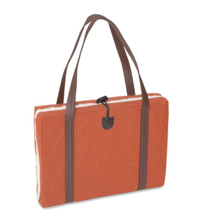 Luxury flooded KONA CAVE® dog mat used as a seat cushion for arenas. Folded  cushion with breathable lining and long shoulder straps for easy transportation. 